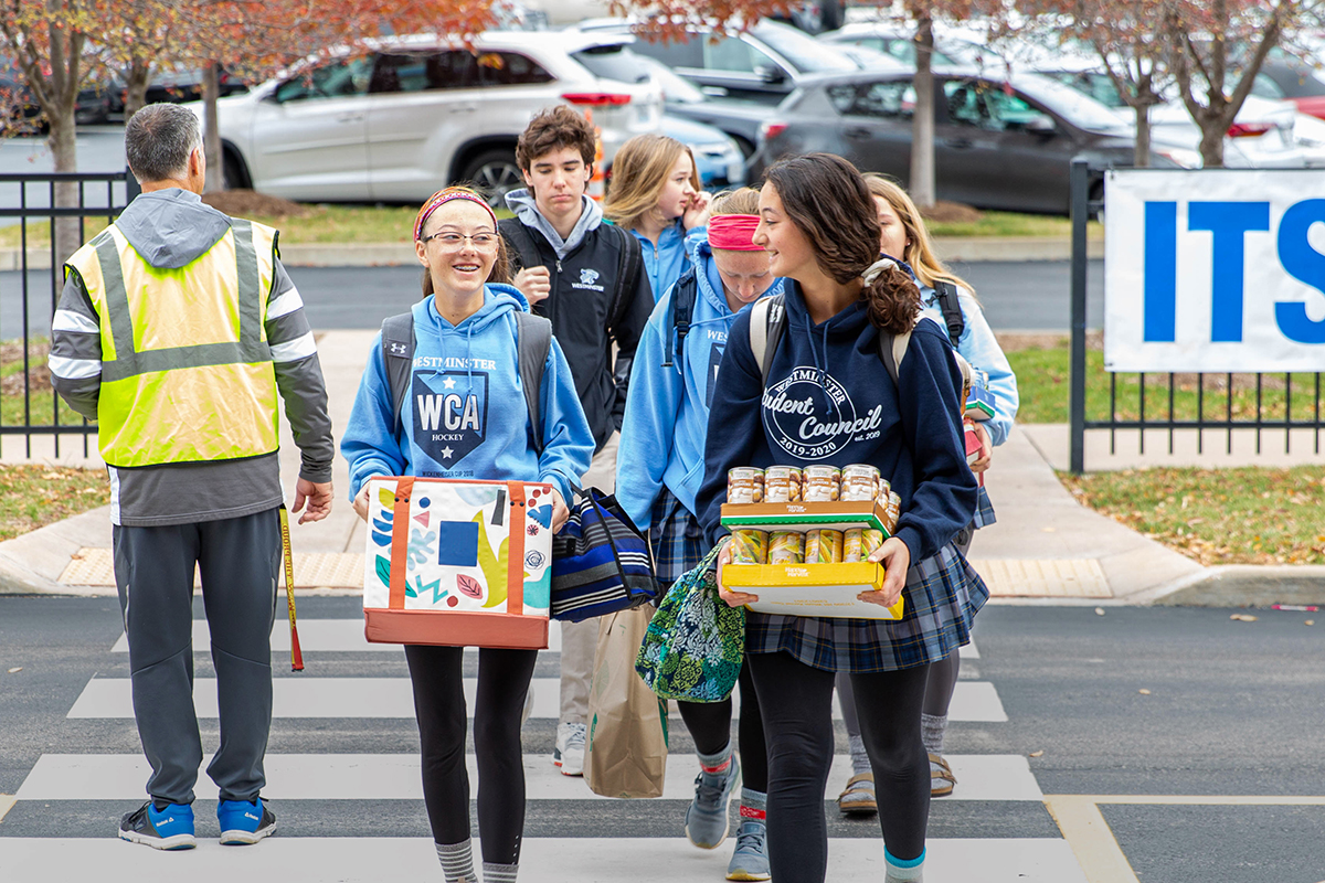 students carrying donations